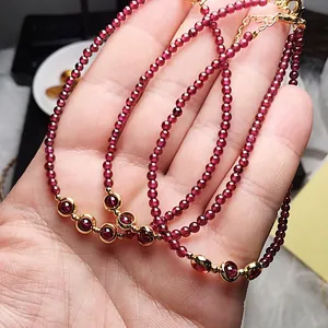 Detailed macro of garnet beaded bracelet with 14K gold lobster clasp and accents