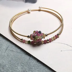 Macro detail of 14K gold filled multi-layer wire bracelet with colorful tourmaline cluster