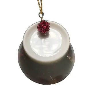 Pendentif boule en grenat avec fine chaîne dorée sur fond blanc pour femme