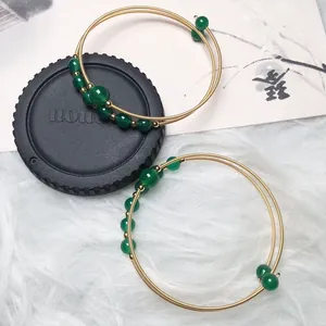 Macro detail of 14K gold filled wire wrapped bracelet with green agate beads