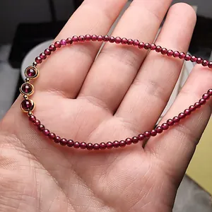 Delicate burgundy garnet beaded bracelet with 14K gold-filled accents in hand display
