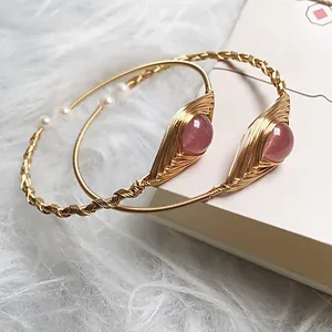 Detail of handmade 14K gold wire wrapped bracelets with strawberry quartz and pearls