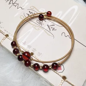 Detailed view of blood amber beads wrap bracelet with 14K gold wire winding craft