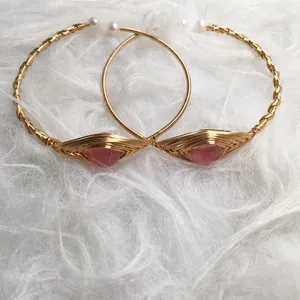 Detail of 14K gold wire-wrapped bracelets with strawberry quartz and pearls on fur