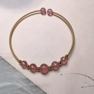 Close-up of strawberry crystal beads on 14K gold-wrapped wire wrap bangle bracelet