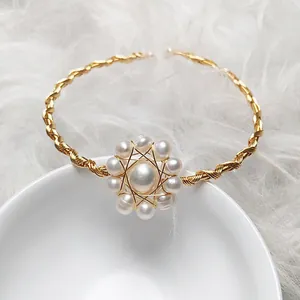 Detail of handmade 14K gold wire twisted bracelet with a freshwater pearl flower bloom