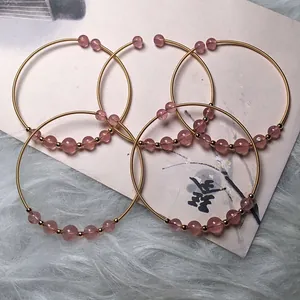 Detail of 14K gold-filled wire wrapped strawberry quartz beads on a 5-piece bracelet set