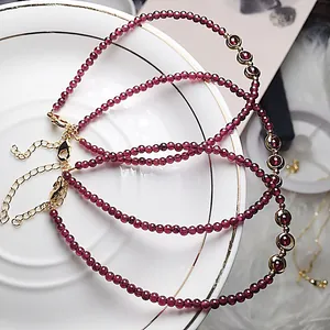Close-up of garnet bead bracelets with 14K gold-filled clasp on a white porcelain tray