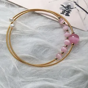 Pink cat eye stone double-loop bracelet with 14K gold wire wrap and pearl accents