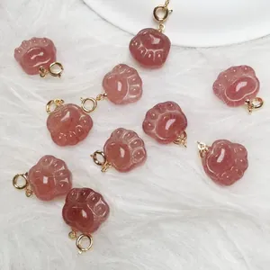 Macro shot of 10 pieces strawberry quartz cat paw pendants on a soft white plush background