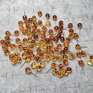 Pendientes de bola estilo ámbar con pasadores de oro de 14K sobre fondo gris