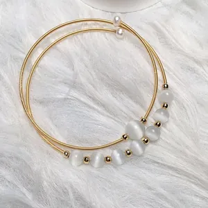 Macro shot of 14K gold-filled multi-layer bracelet with cat eye beads and pearls