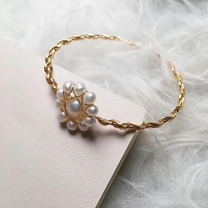 Handmade 14K gold wire wrapped bangle featuring white freshwater pearl flower charm