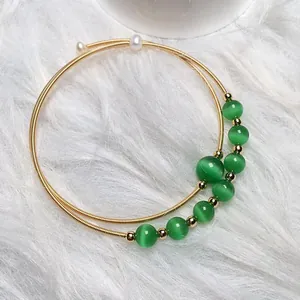 Detailed view of 14K gold filled memory wire bracelet with green cat eye beads and pearls