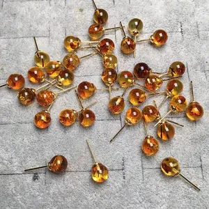 Pendientes de ámbar natural con degradados cálidos sobre fieltro gris y postes de oro 14K