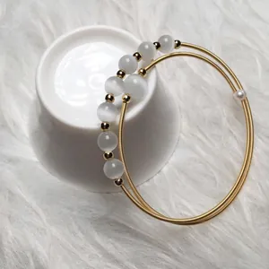 Elegant double-layered 14K gold plated bracelet with white cat eye stones and small pearl