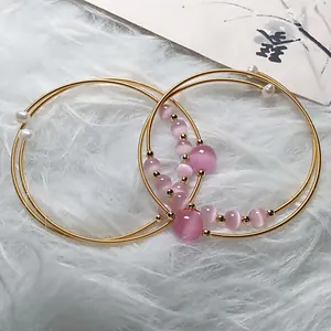 Pink cat eye stone bracelet with 14K gold wire wrap craft and pearls on white fur