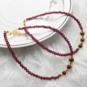 Close-up of deep red garnet beaded jewelry set with 14K gold filled lobster clasp accents