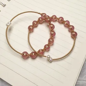 Detail of strawberry quartz bracelet with 14K gold wire wrapping and white pearls