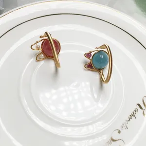 Detailansicht der handgefertigten Ohrringe aus 14K Gold mit Erdbeerquarz und Drahtwicklung