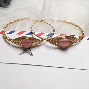 Detail of strawberry quartz evil eye cuff with 14K gold wire wrap and pearls