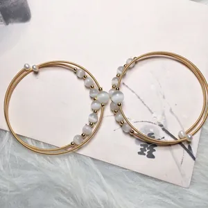 Detail of 14K gold-filled multi-wrap bracelet with white cat eye beads and pearls