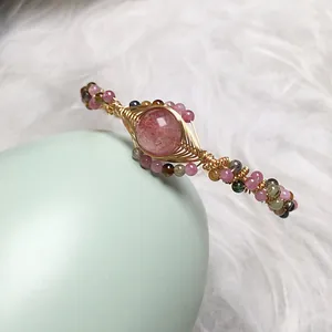 Detailed macro view of strawberry quartz and tourmaline beads on 14K gold wire hand-wrapped cuff