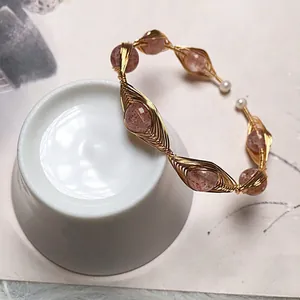 Detail of handmade 14K gold wire wrapped bangle with strawberry quartz and pearls