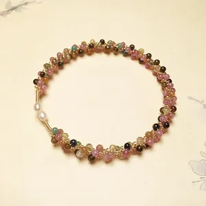 Macro detail of colorful tourmaline beads and white pearls with 14K gold-filled wire wrap