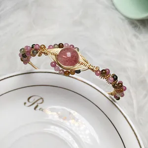 Detail of strawberry quartz bracelet with 14K gold wire wrap and multicolor tourmaline