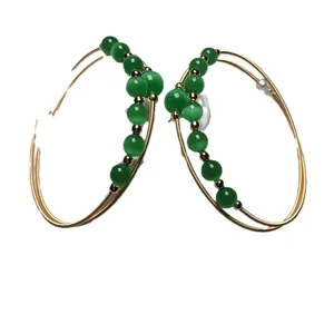 Bohemian gold wire hoop earrings with green cat eye beads and white pearl accents