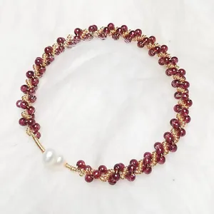 Detail of garnet beaded bracelet with 14K gold accents and twin freshwater pearls