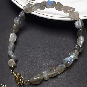 Detailopname van natuurlijke labradoriet armband met blauwe glans en gouden verstelbare ketting
