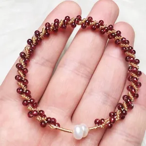 Detail of garnet beaded bracelet with gold wire wrapping and two white pearl accents