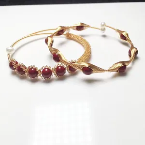 Detail of handmade 14K gold filled wire wrapped bracelet with red beads and pearls