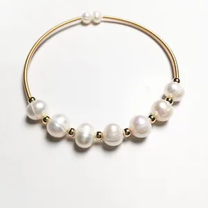 Detailed close-up of 14K gold wire bracelet with seven natural white freshwater pearls