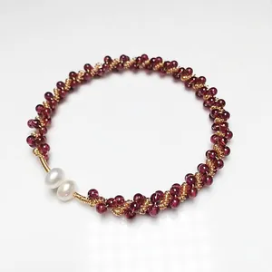 Detailed cluster of garnet beads with freshwater pearls and 14K gold-filled wire on a white base