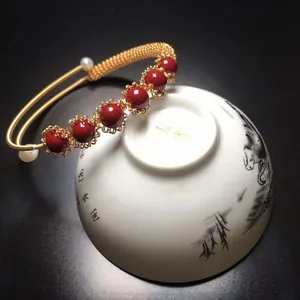 Elegant gold-plated bracelet featuring five red cinnabar beads and white pearl accents