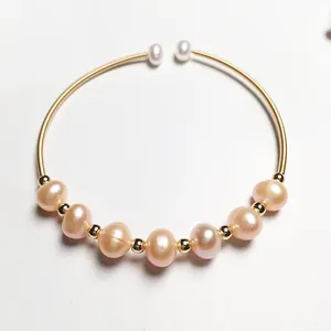 Detail of 14K gold-filled wire bracelet featuring pink pearls and white pearl tips
