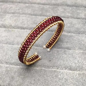 Handcrafted gold wire wrapped bangle with red garnet beads and pearl accents