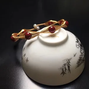 Handcrafted gold wire wrapped bangle with red beads and white pearls in ethnic style