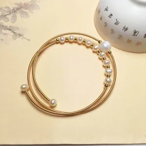 Macro view of multi-layer 14K gold-filled wire bracelet with freshwater pearls