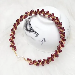 Detail of garnet beaded bracelet with 14K gold wire wrap and elegant white pearls