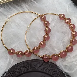 Detail of 14K gold-filled wire-wrapped bangles with strawberry quartz and pearls