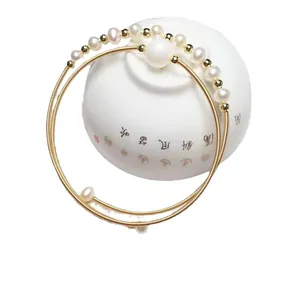 Double-layer spiral freshwater pearl bracelet with 14K gold plated beads in a porcelain bowl