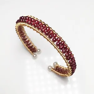 Detail of wire-wrapped garnet bead bracelet with gold finish and pearl accents