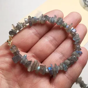 Macro-opname van natuurlijke labradoriet armband met blauwe glans en gouden sluiting