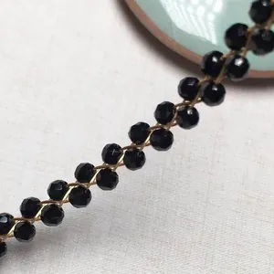 Macro shot of garnet beads with 14K gold plated wire weaving details on the bracelet