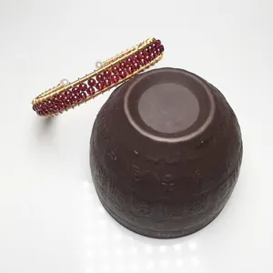 Detail of handmade wire-wrapped gold bracelet with red garnets and white pearls