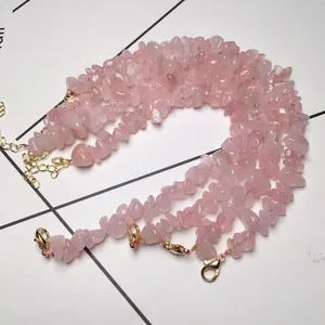 Macro detail of pink crystal chip bracelets with gold plated lobster clasps and chains